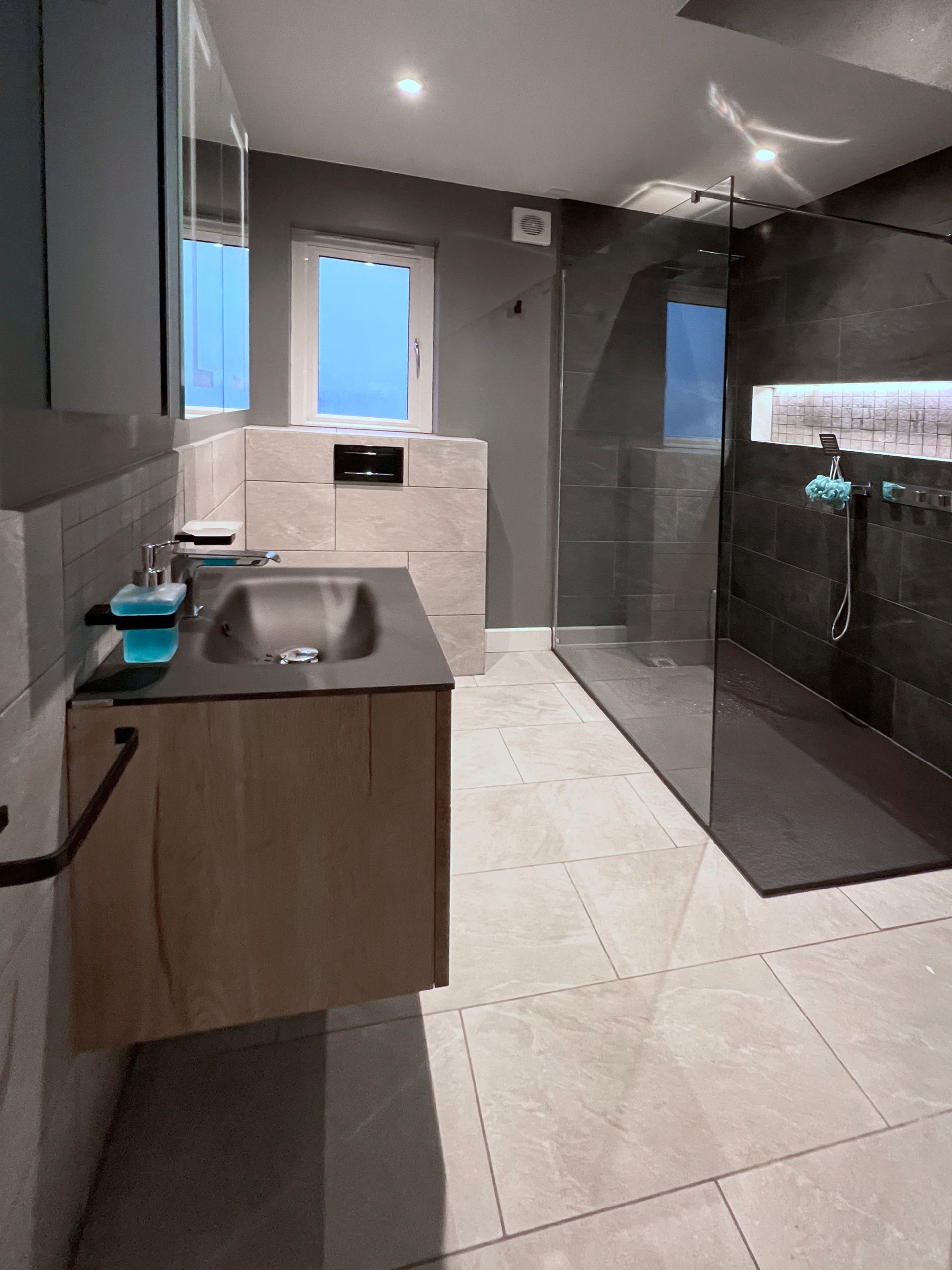 A bathroom with a sink and a walk in shower