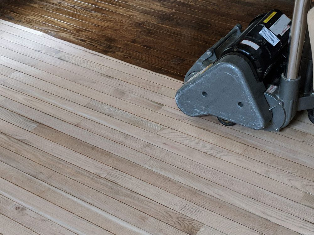 A Machine Is Being Used To Sand A Wooden Floor — Byron Floor Sanding In Byron Bay, NSW