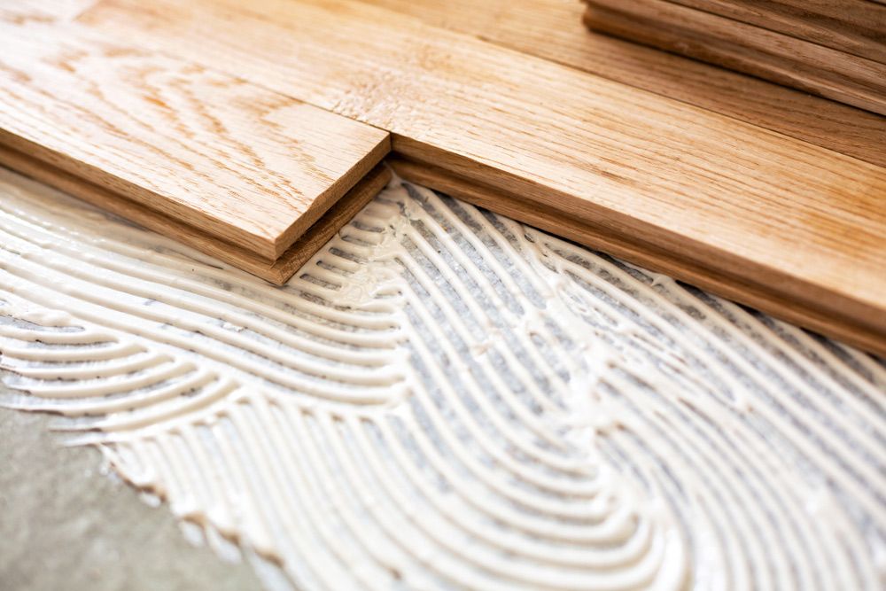 A Close Up Of A Wooden Floor Being Installed With Glue — Byron Floor Sanding In Lismore, NSW