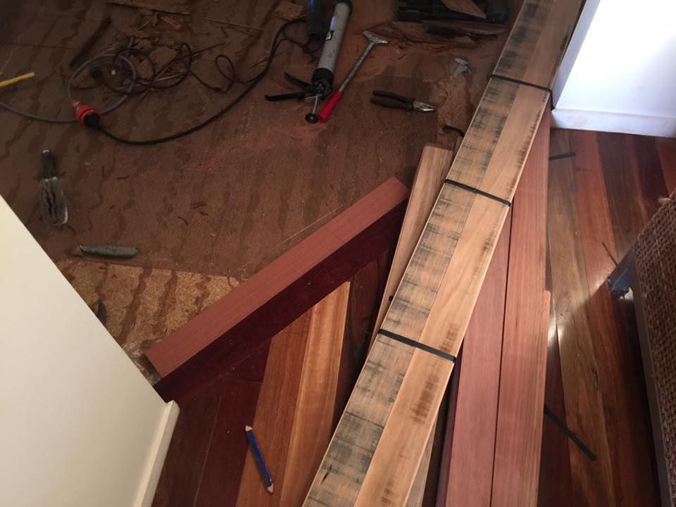 A Bunch Of Wood Laying On The Floor With Tools — Byron Floor Sanding In Tintenbar, NSW