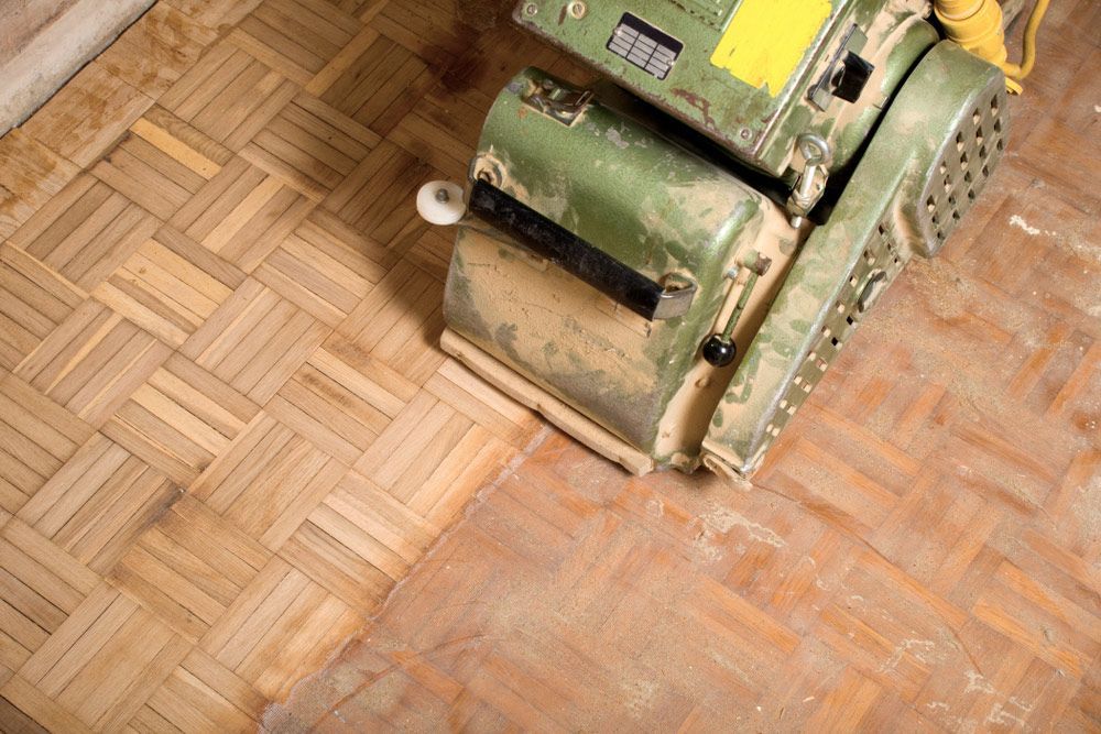 A Machine Is Sanding A Wooden Floor — Byron Floor Sanding In Yamba, NSW