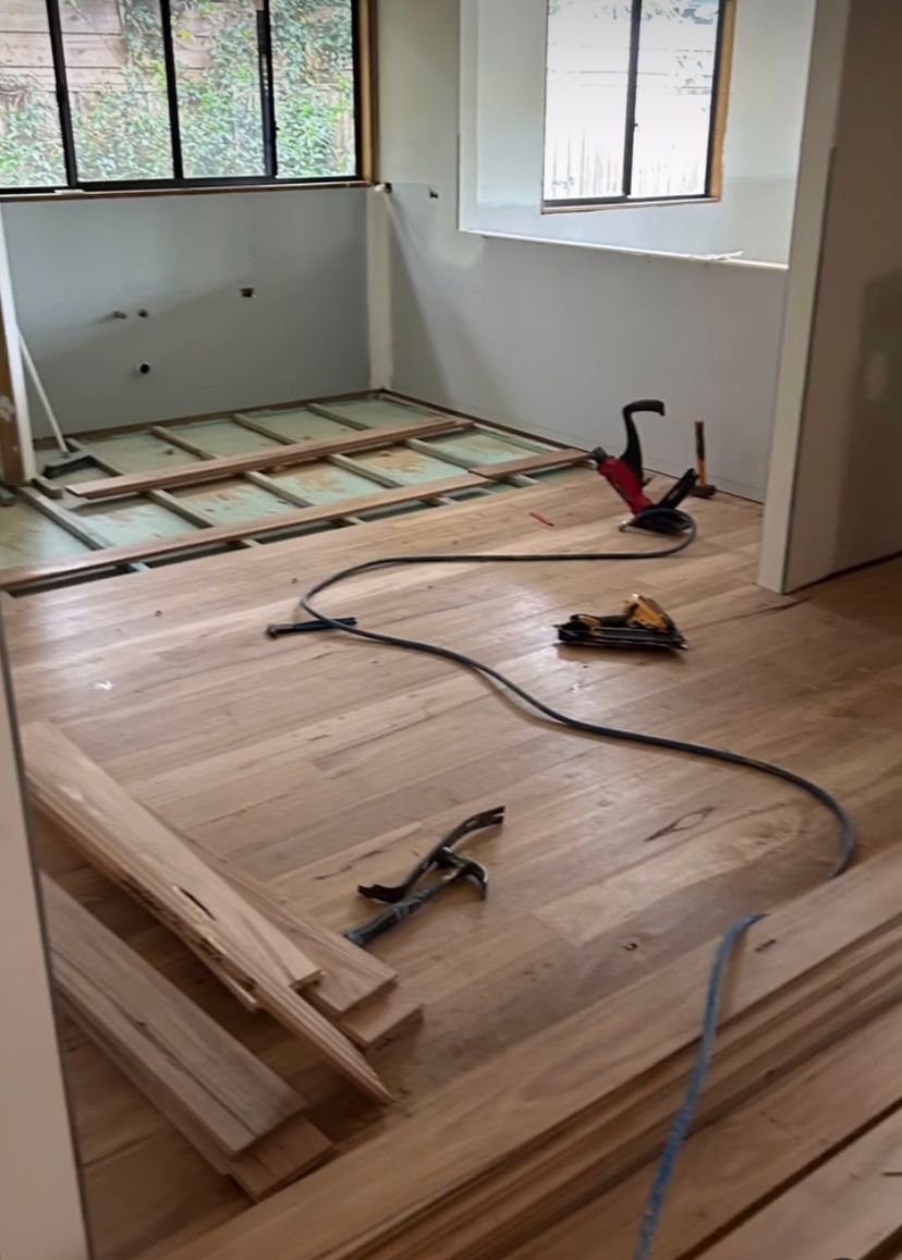A Wooden Floor is Being Built in In A Room with Tools On the Floor — Byron Floor Sanding In Lismore, NSW