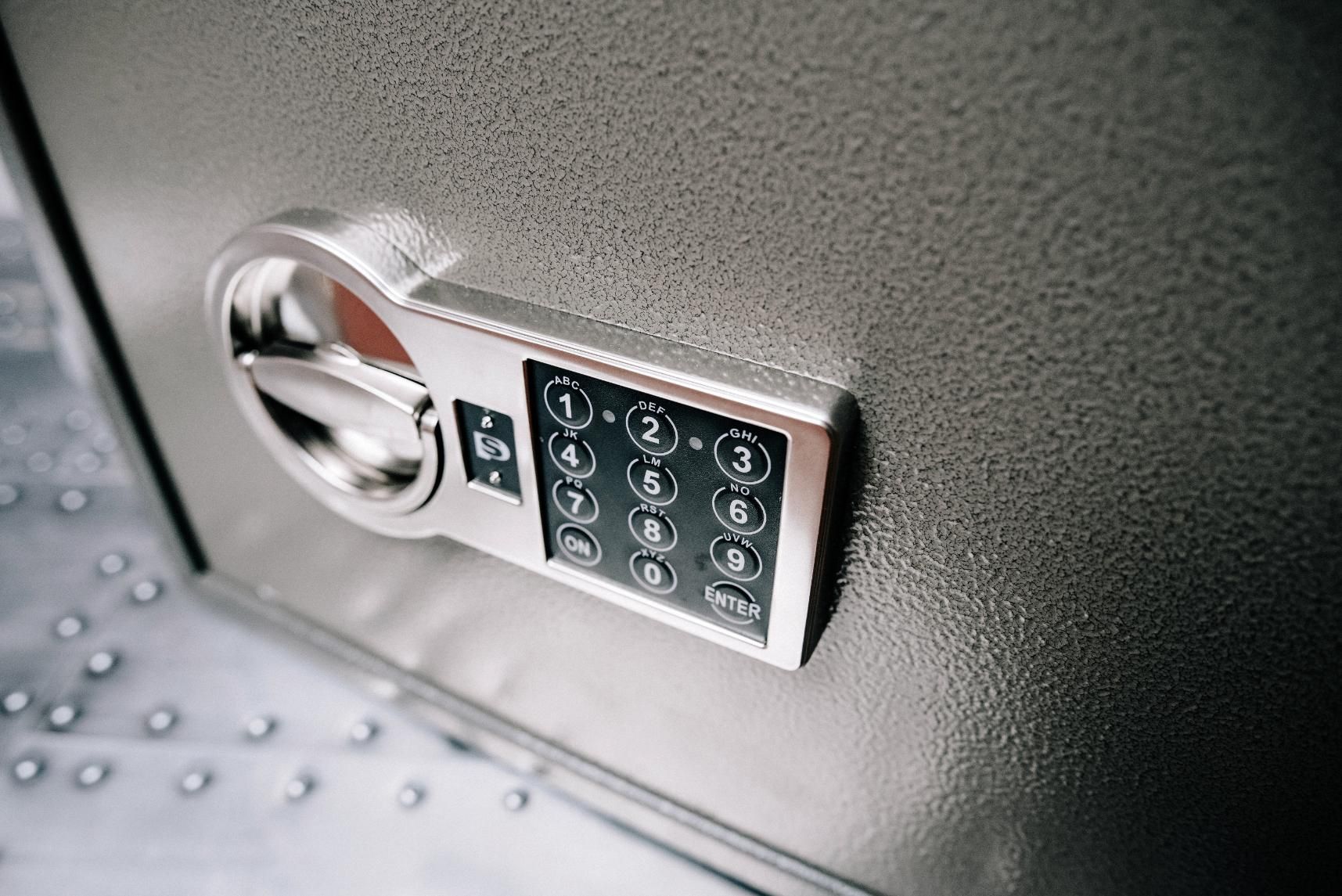 Close-up of a gray safe with a keypad and dial. 