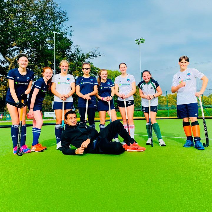A group of hockey players posing for a picture on a field