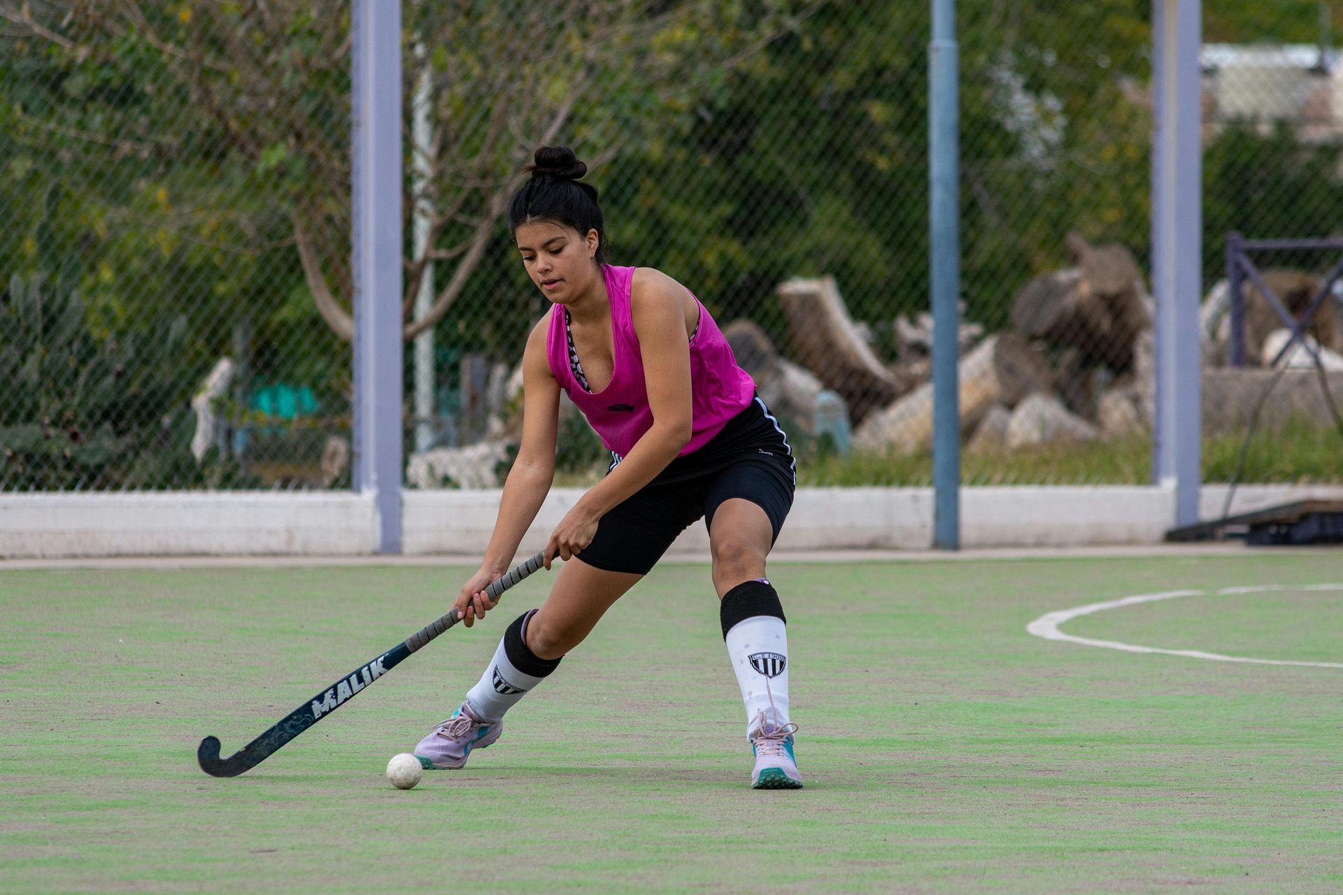 A woman is playing field hockey on a field.