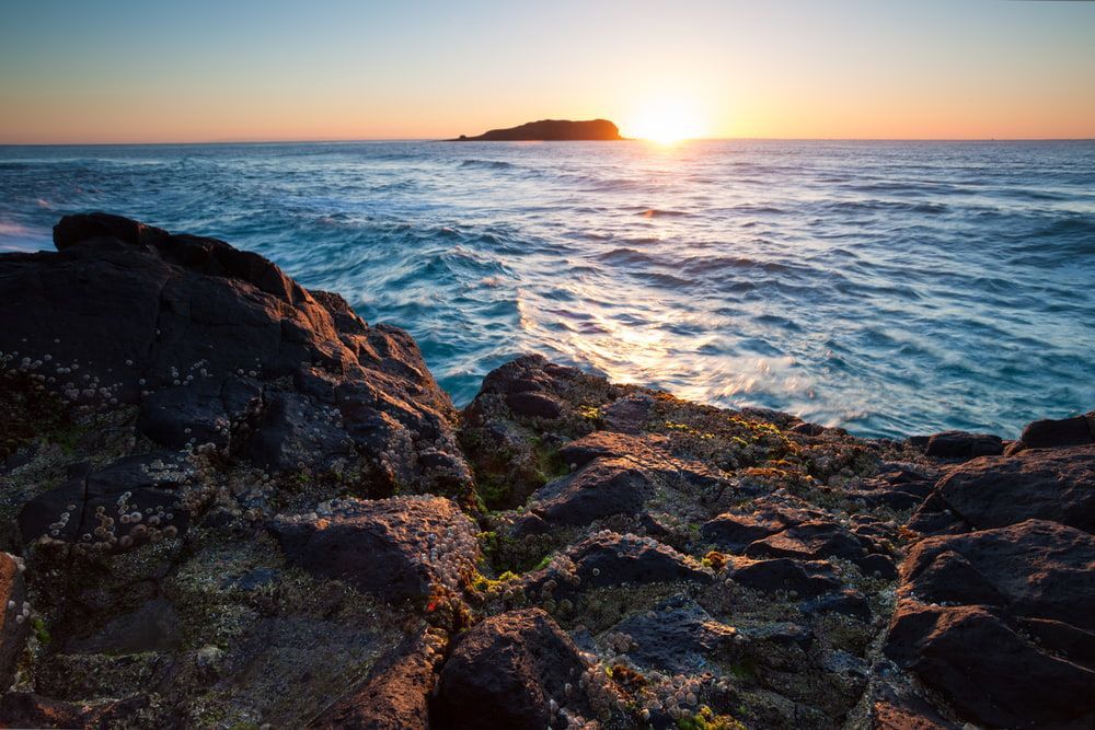 Sun is Setting Over the Ocean With a Small Island — Gary Arnold Water Supplies in Tweed Coast, NSW