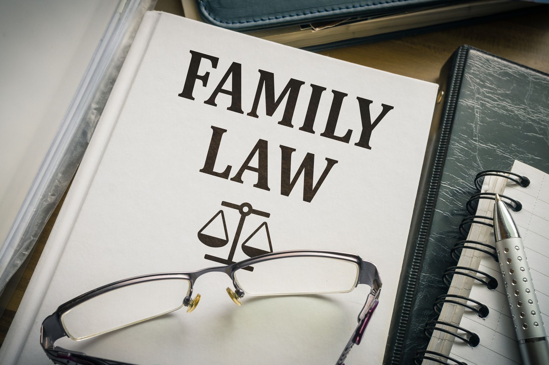 A book titled family law is sitting on top of a notebook.