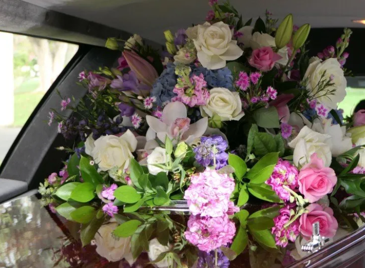 A colorful bouquet of roses and wildflowers in the back seat of a car