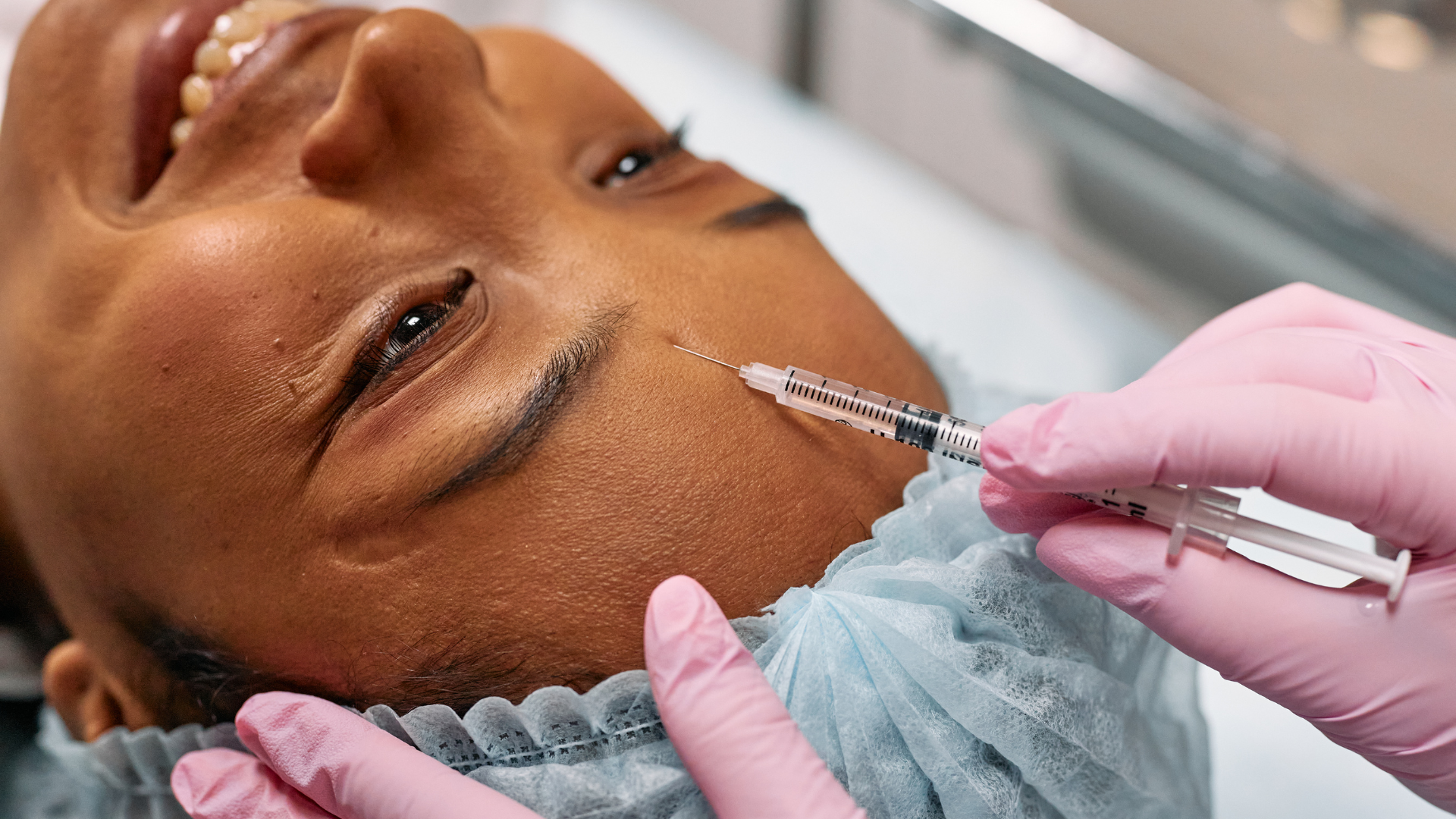 A woman is getting a botox injection in her face.