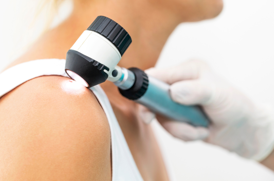 A doctor is examining a woman 's shoulder with a light.