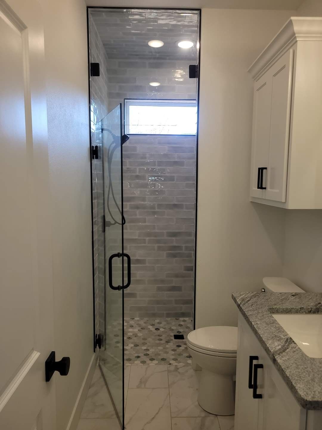 A bathroom with a walk in shower and a toilet