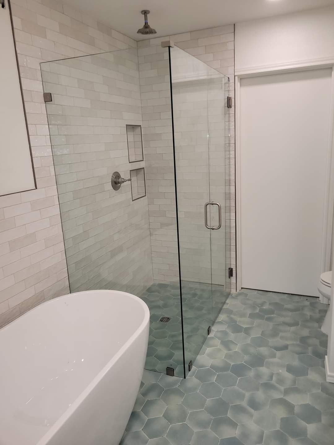 A bathroom with a bathtub and a walk in shower.