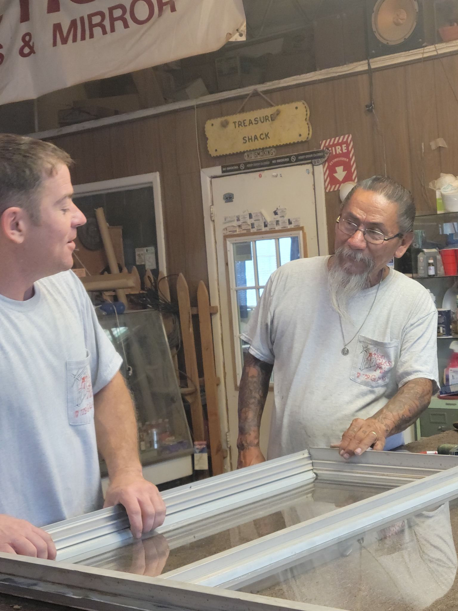 Two men are standing in front of a sign that says mirror