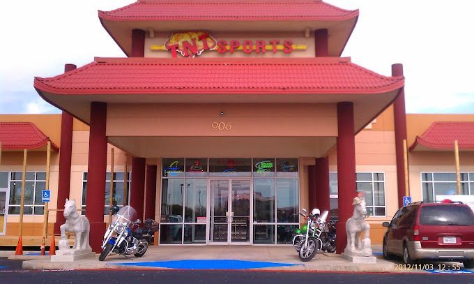 Two motorcycles are parked in front of the entrance to a restaurant
