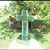 A cross is sitting in the grass in front of a tree.