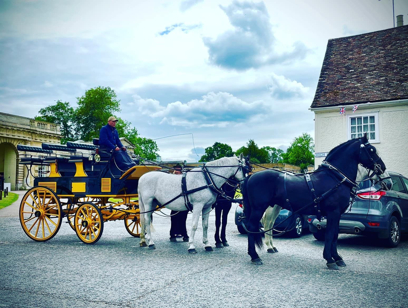 A horse drawn carriage is parked in front of a building