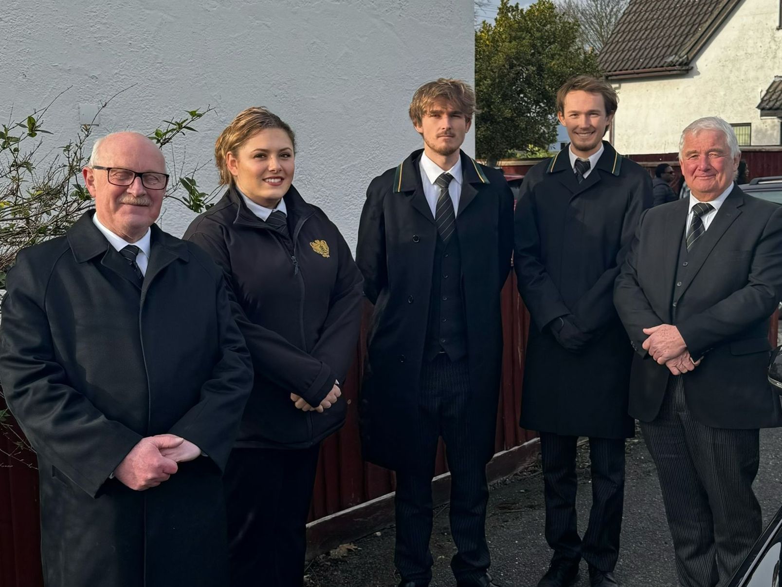 A group of people standing next to each other in front of a building