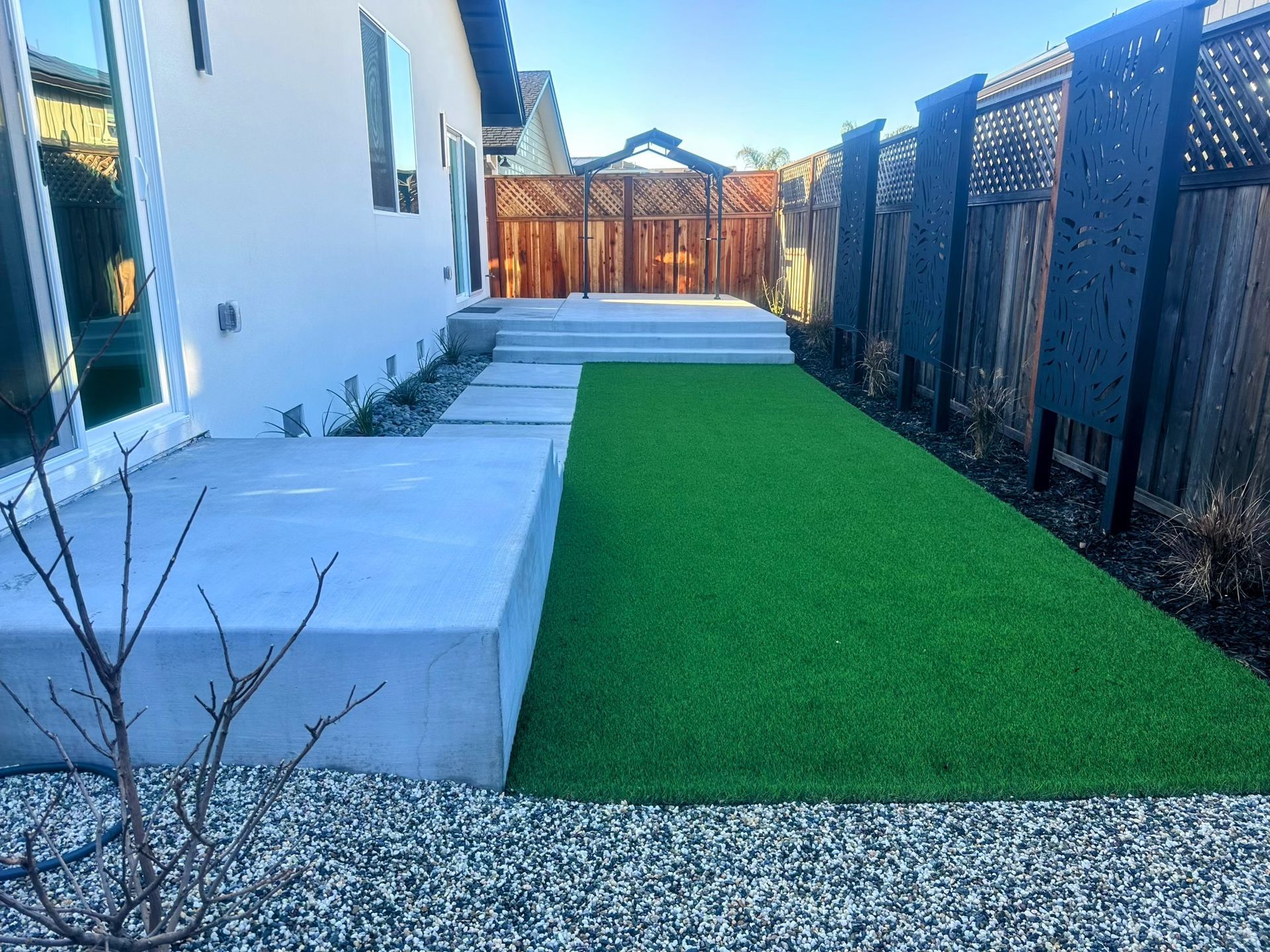 A walkway leading to a house next to a body of water.