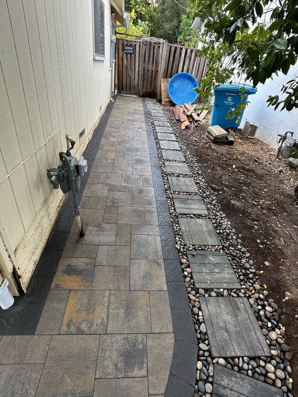 A walkway leading to a house next to a body of water.