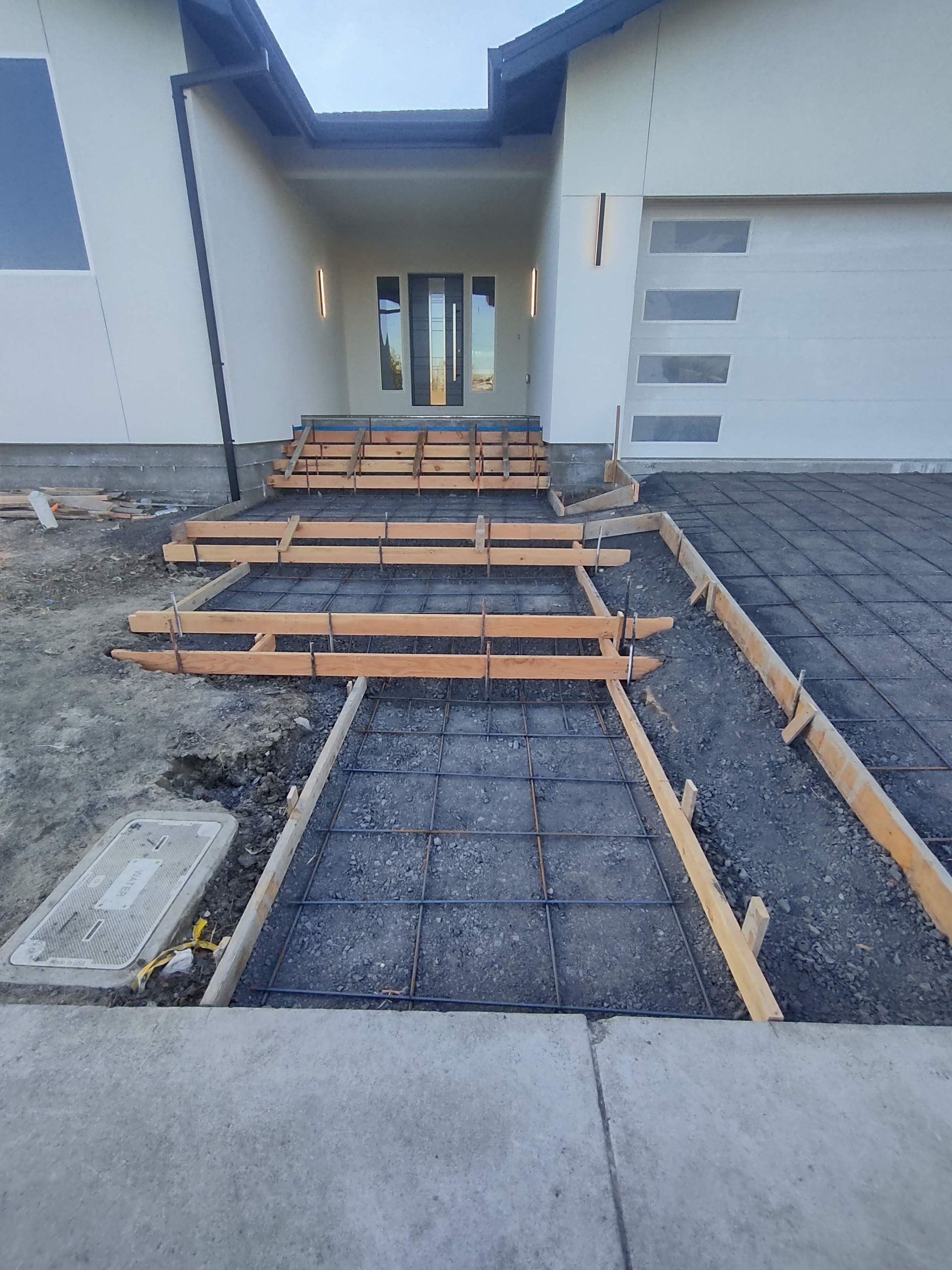 A concrete walkway is being built in front of a house.