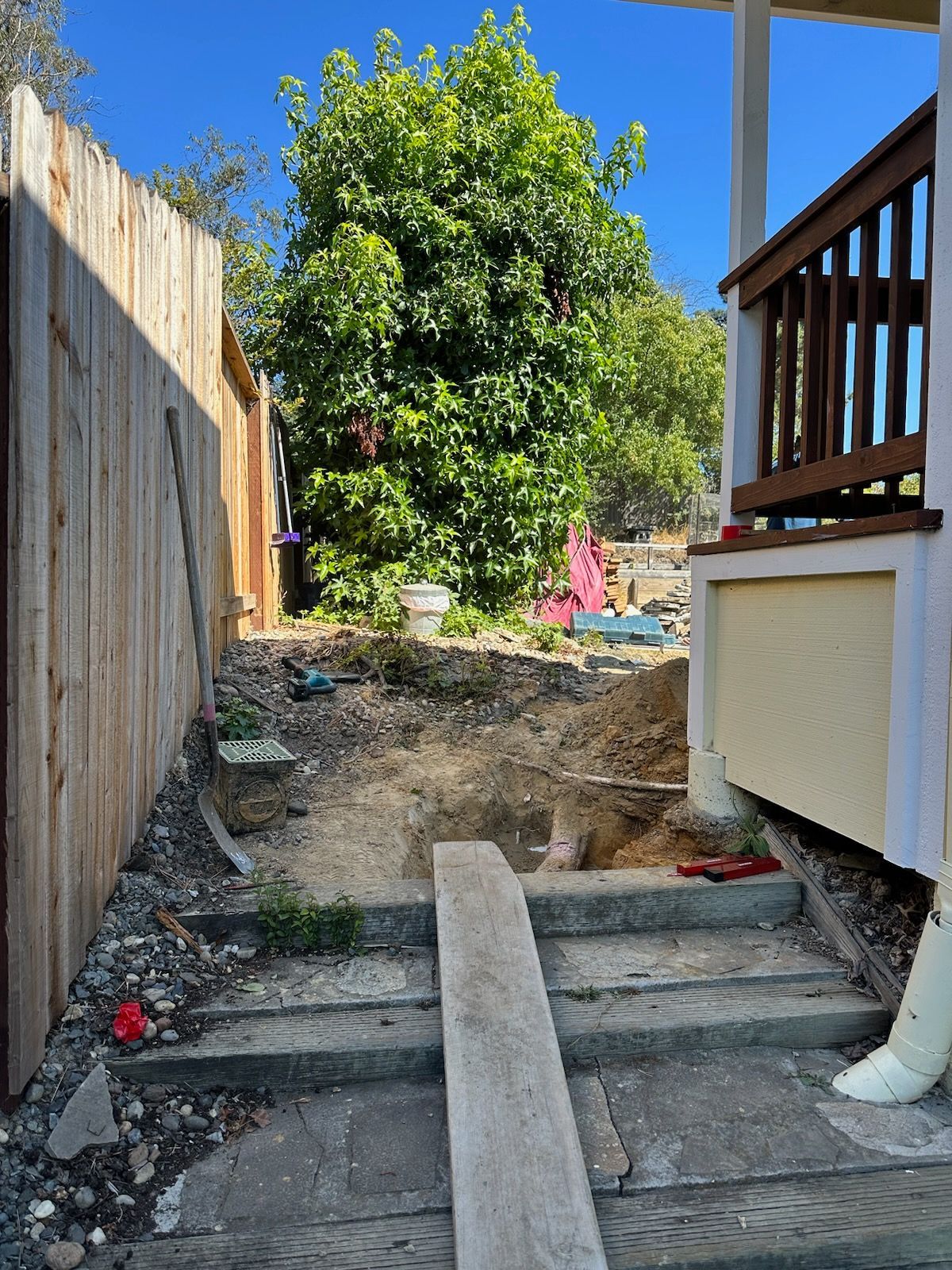 A wooden fence surrounds a staircase leading up to a house.