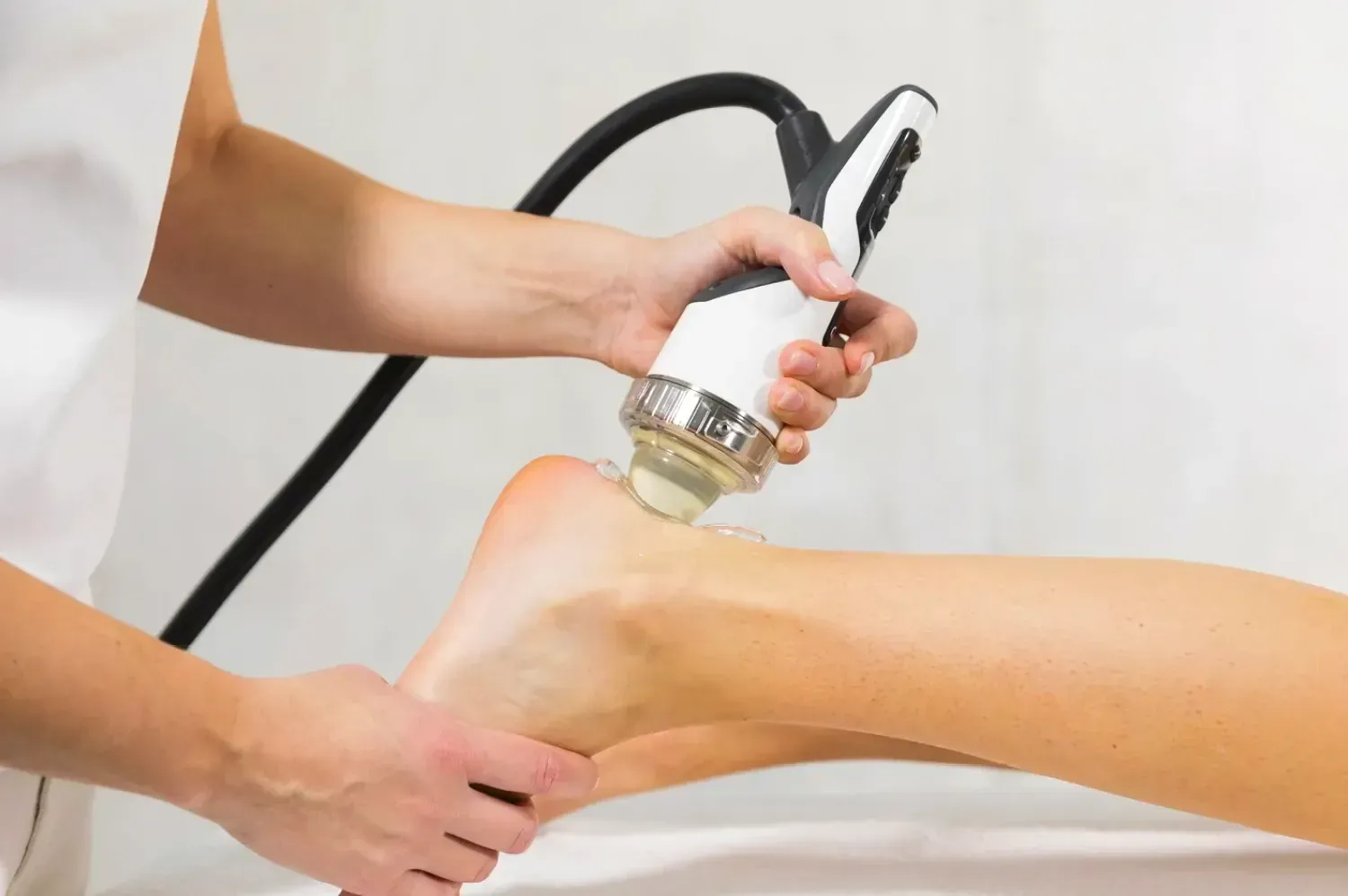 A woman is getting an shockwave treatment on her tendon