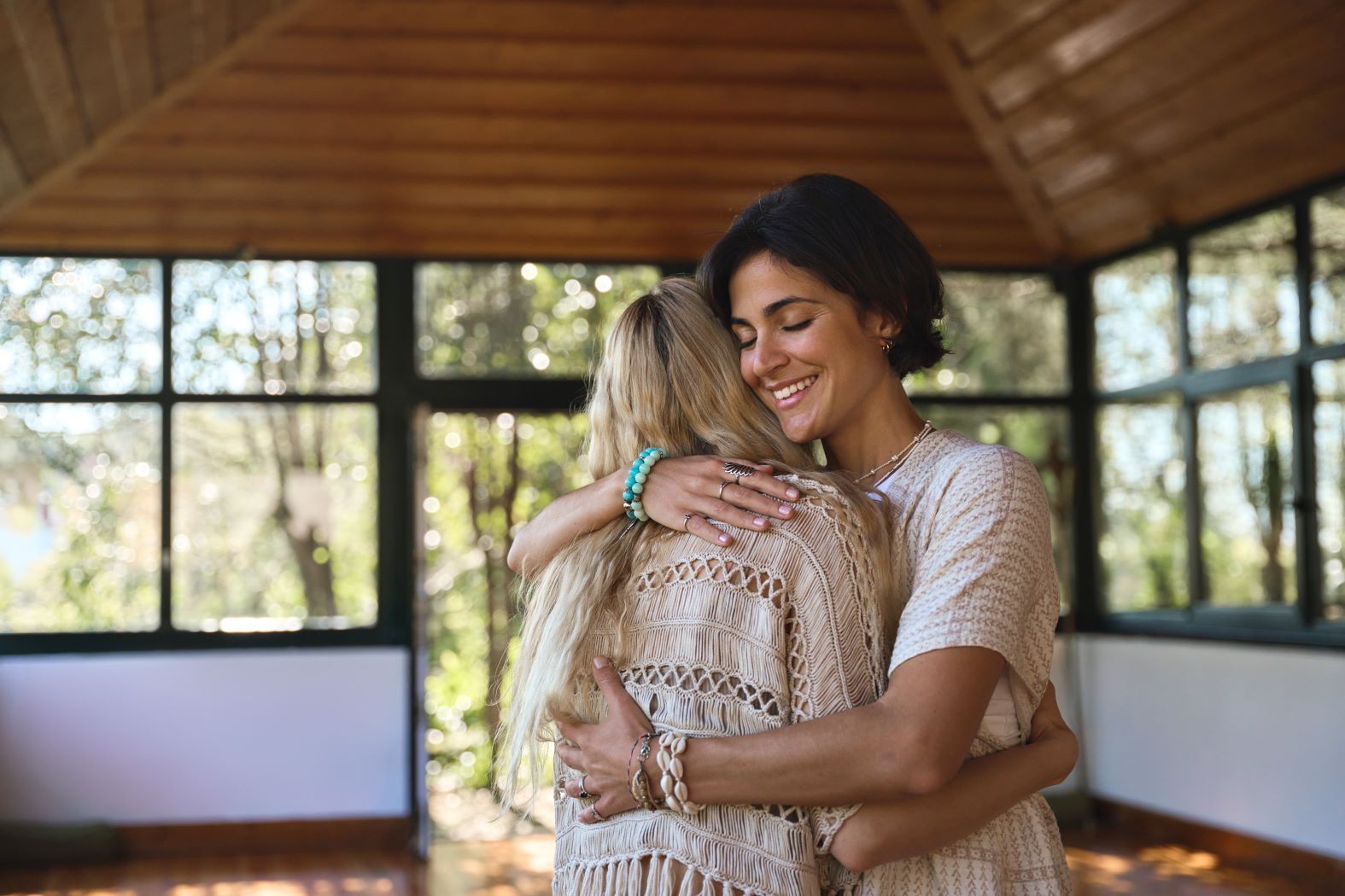 Two women are hugging each other in a room.