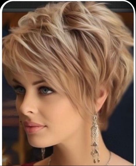 Close-up portrait of a person with short blonde hair and dangling earrings, looking left.