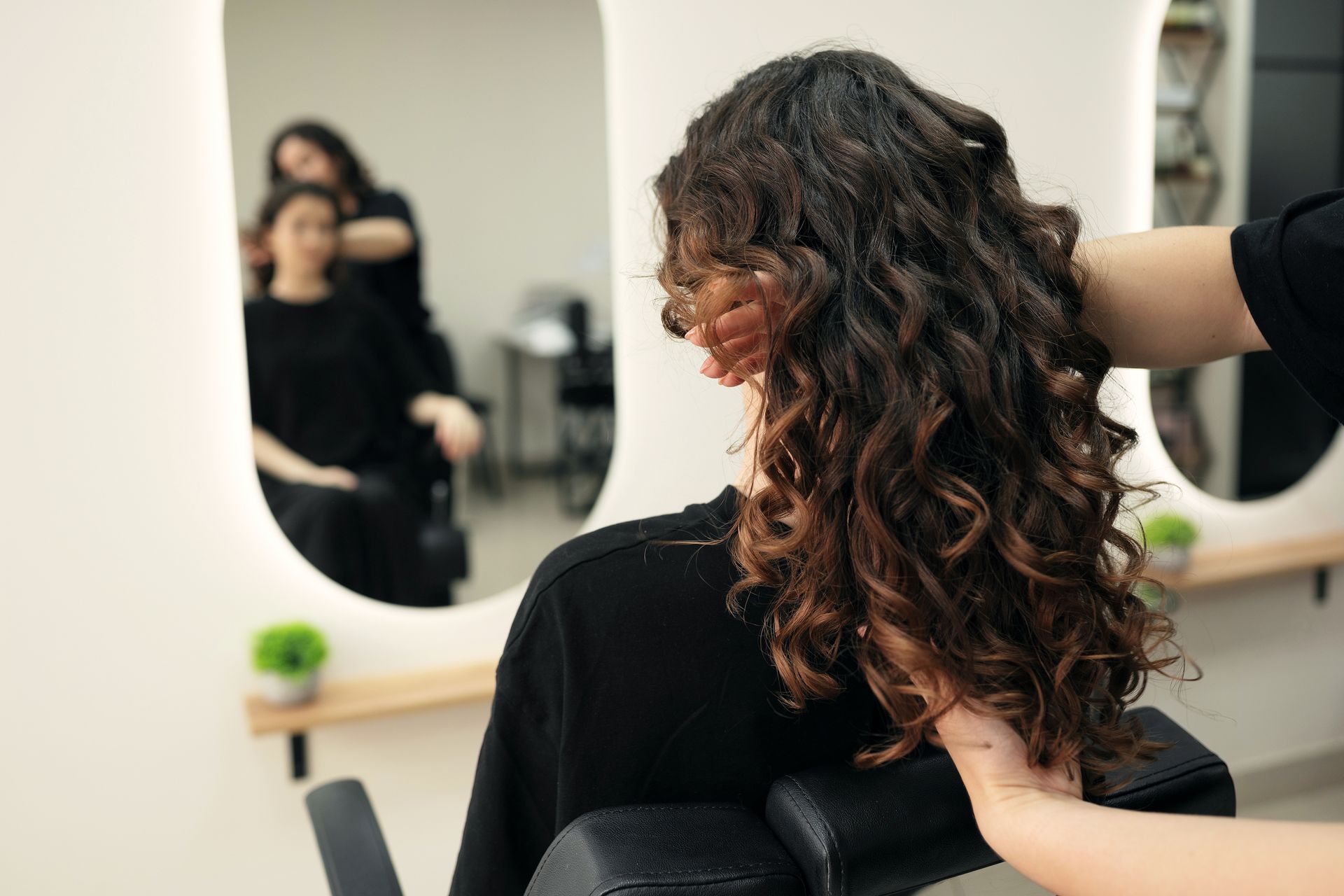 Stylist carefully wrapping hair onto a perm rod at Town Salon