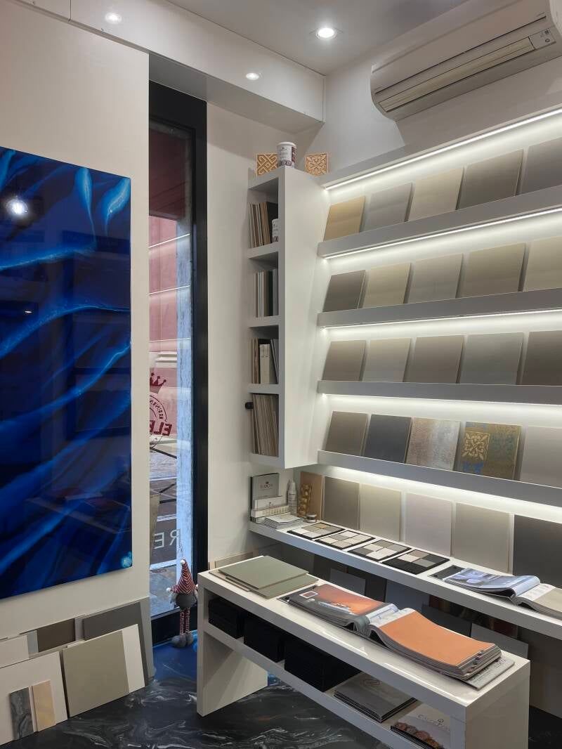 Interno di uno showroom di piastrelle con campioni di piastrelle su scaffali.