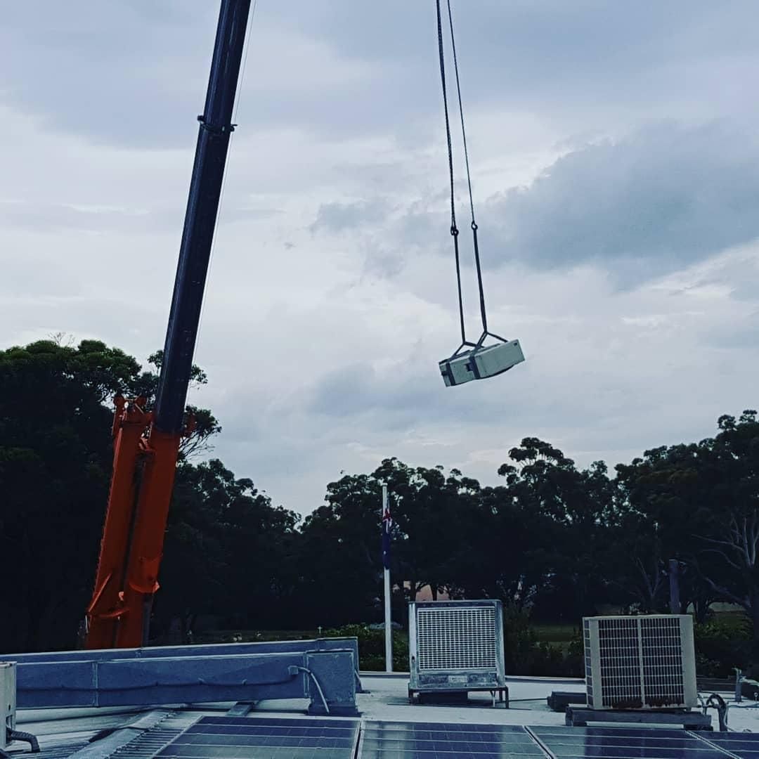 A Crane is Lifting an Air Conditioner — Atmosphere Air Conditioning & Refrigeration In Taylors Beach, NSW