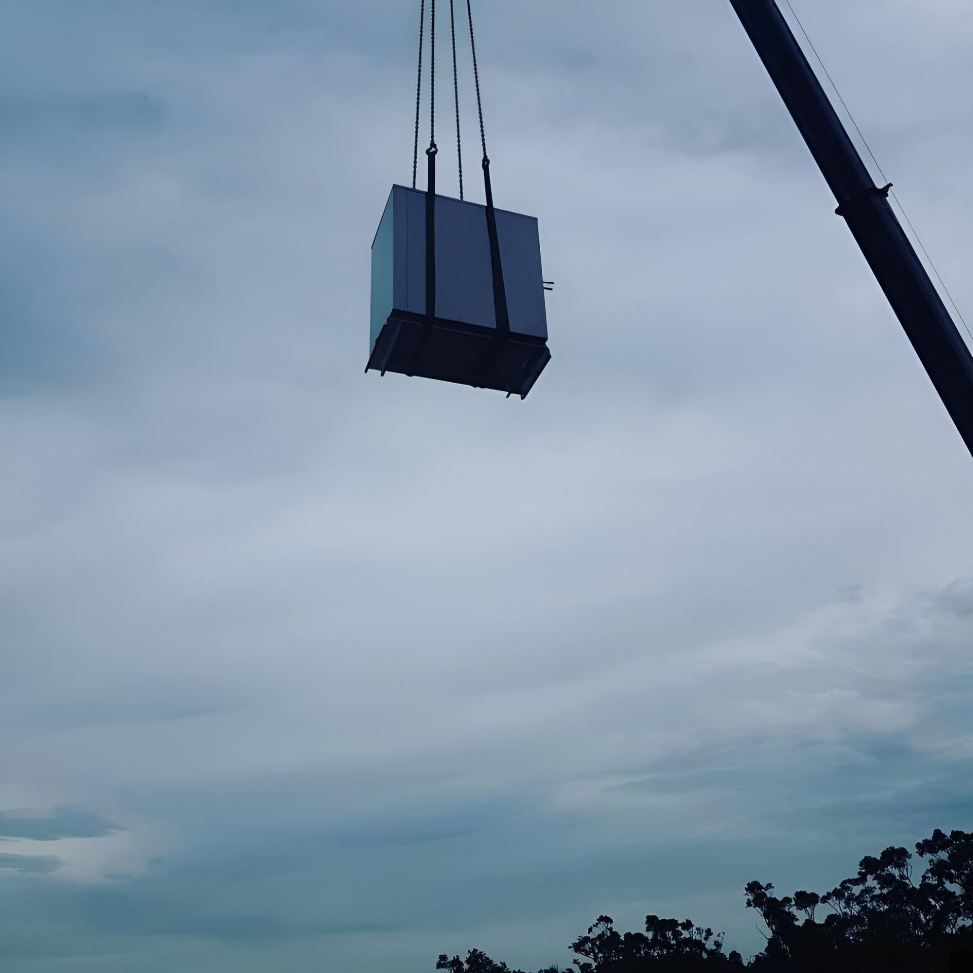 A Large Box is Being Lifted by a Crane in the Sky — Atmosphere Air Conditioning & Refrigeration In Taylors Beach, NSW