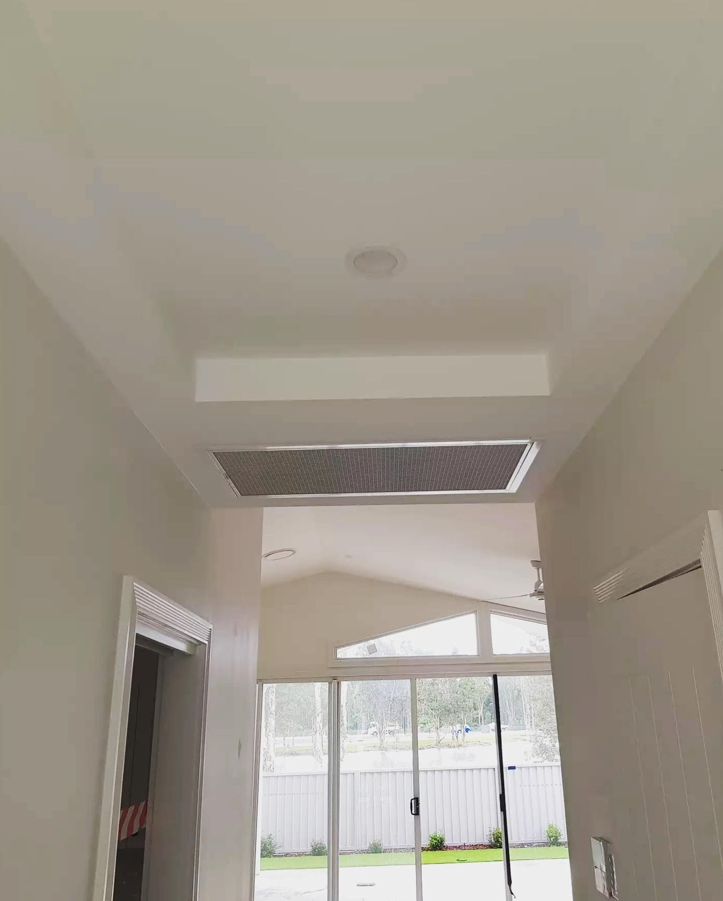 A Hallway With a Ceiling Fan and a Sliding Glass Door — Atmosphere Air Conditioning & Refrigeration In Taylors Beach, NSW