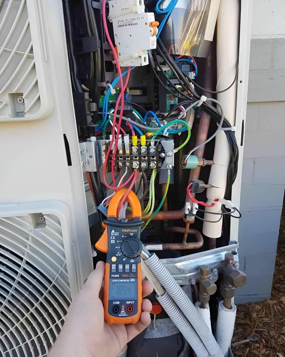 A Person is Holding a Clamp Meter — Atmosphere Air Conditioning & Refrigeration In Taylors Beach, NSW