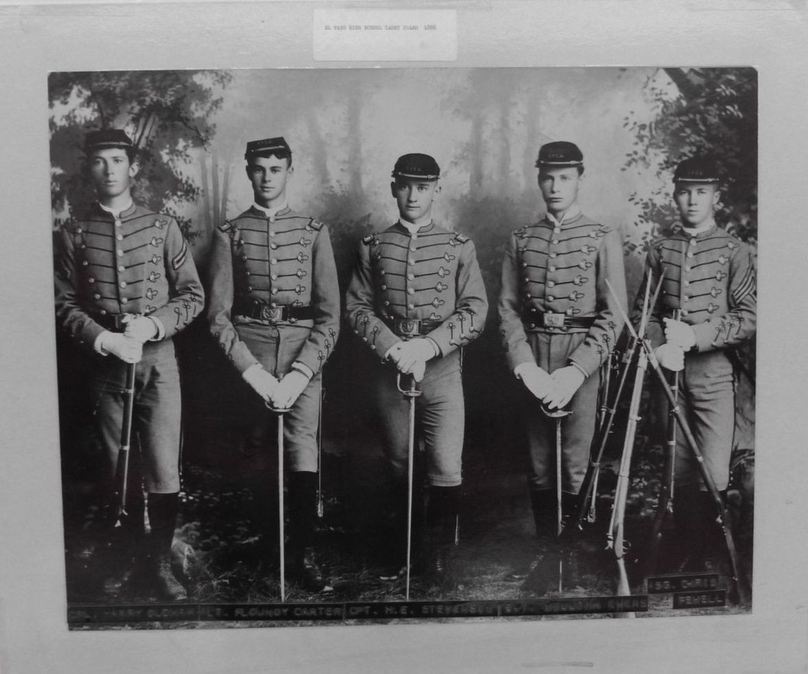 A group of men in military uniforms are standing next to each other holding swords.