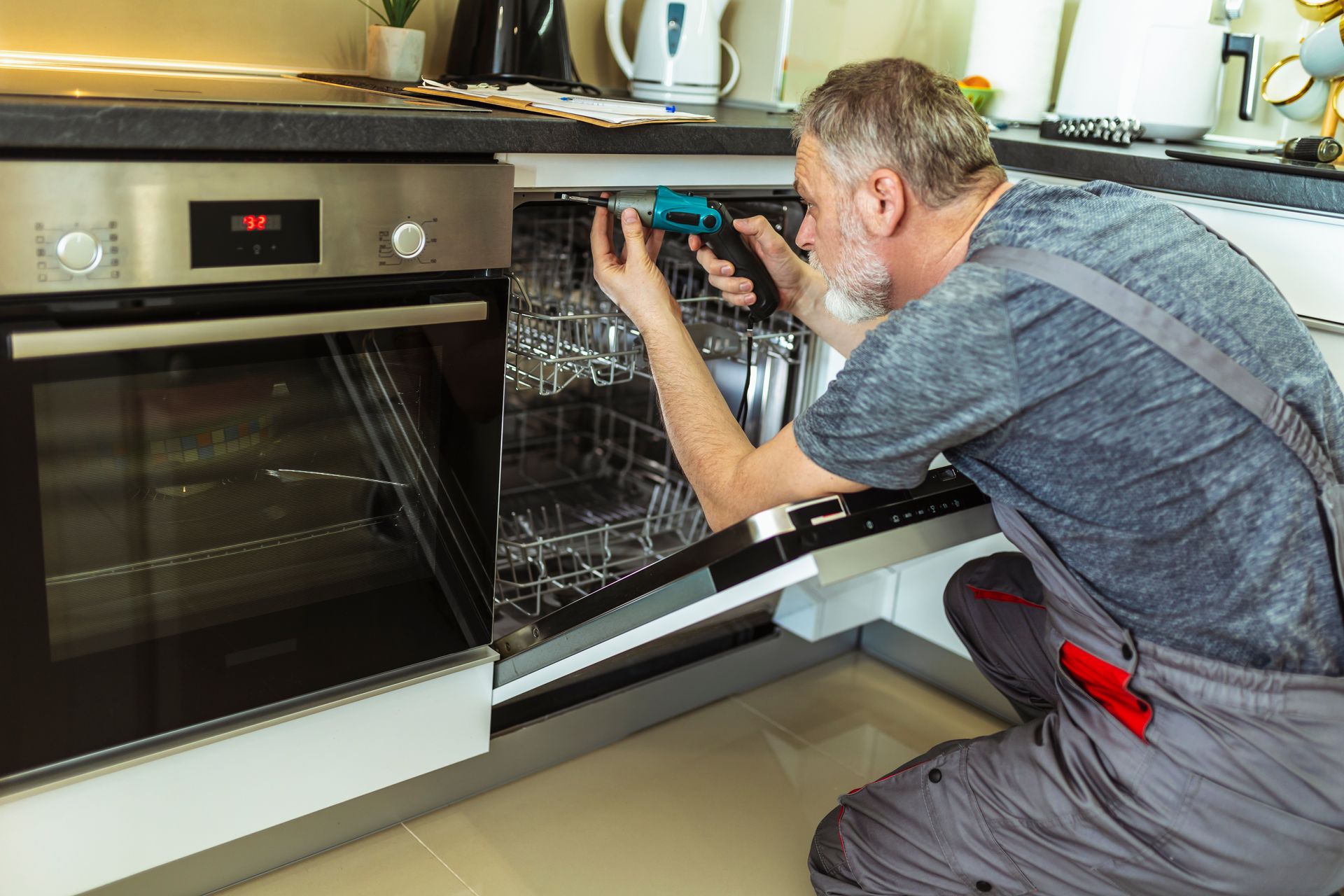 Appliance repair expert fixing a dishwasher. Appliance repair expert fixing a dishwasher.