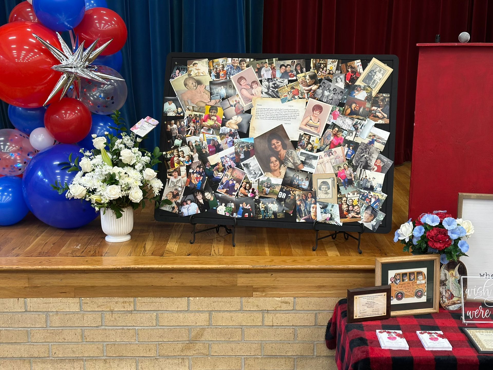 Stage with balloons, a photo collage, and floral arrangements.