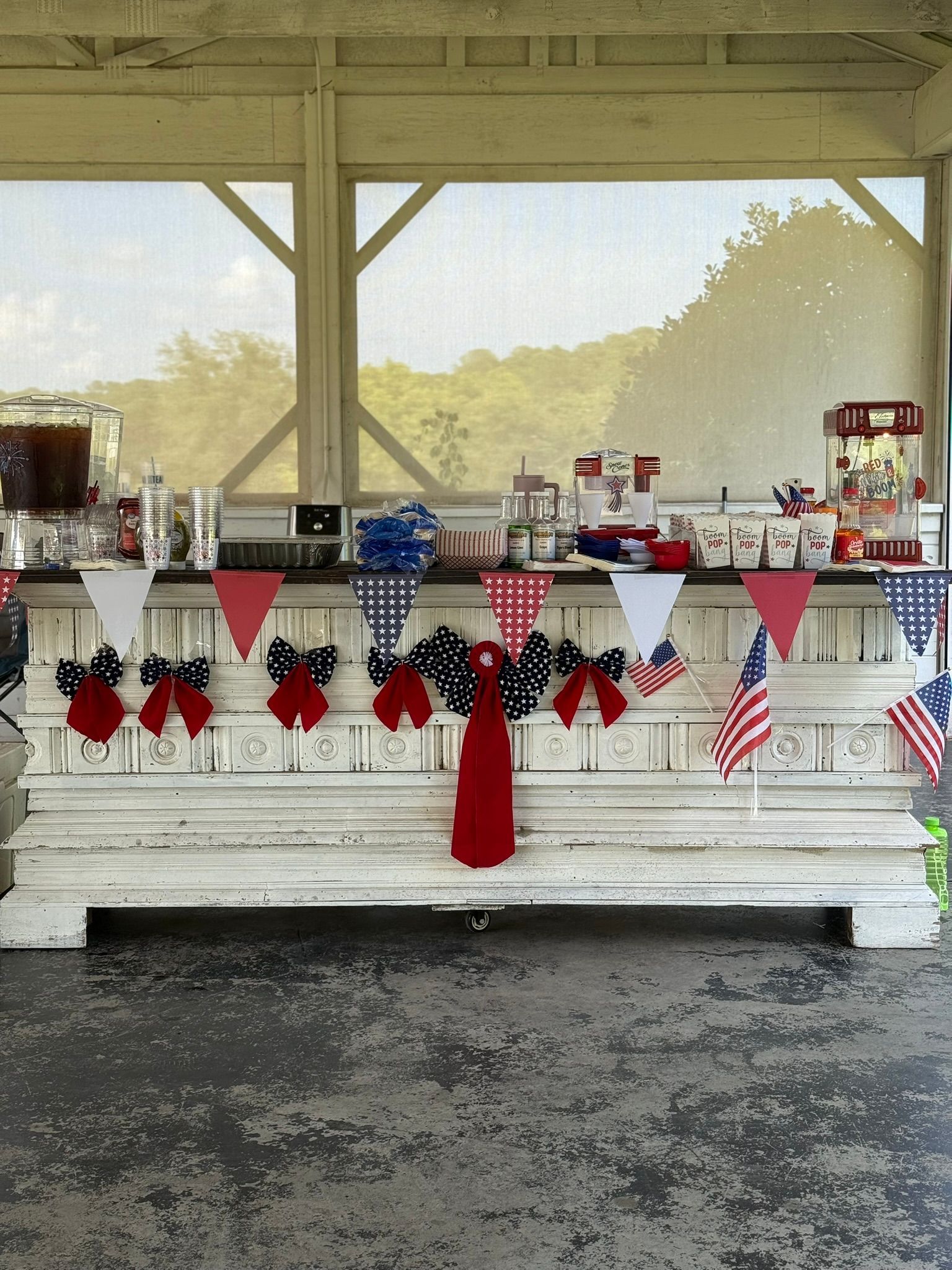 White bar decorated with red, white, and blue for a celebration. American flags and pennants adorn the front.