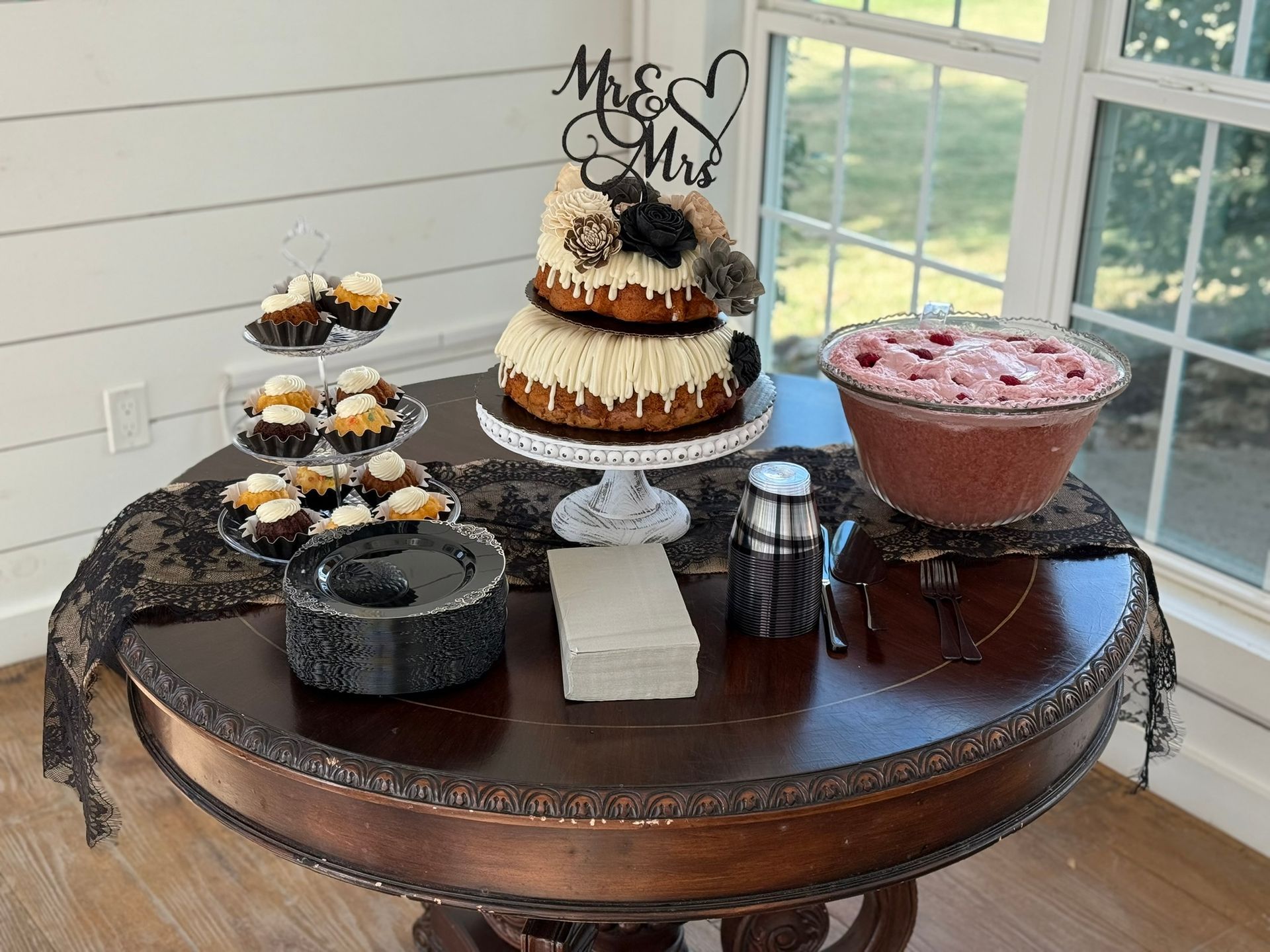 Cake and desserts on a table with lace. Punch bowl, cupcakes, and a cake with 