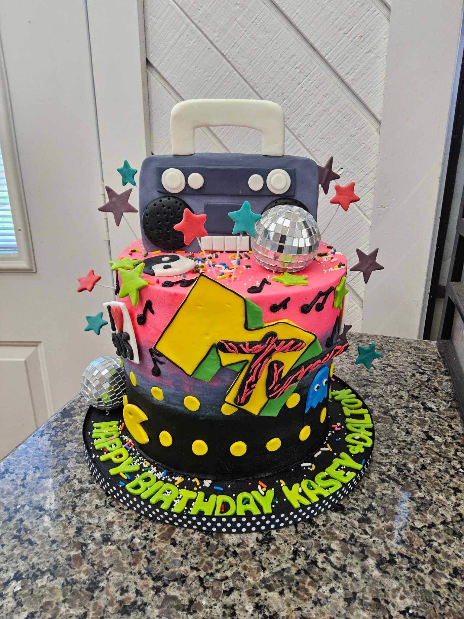 80s-themed birthday cake with MTV logo, boombox, disco ball, and star decorations; 