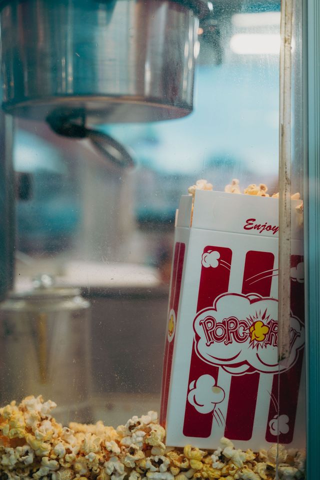 Popcorn machine with striped popcorn bag in front of glass window