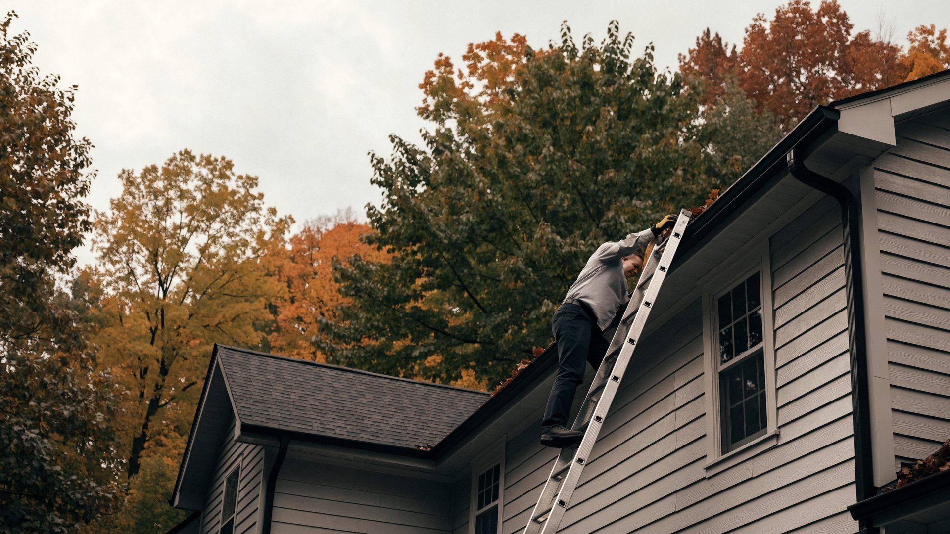 homeowner checking gutters during seasonal home maintenance in Somerset County NJ