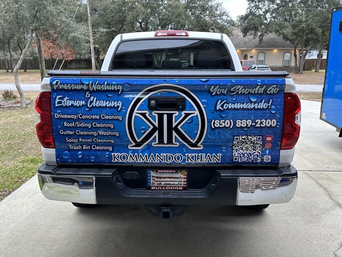 Rear view of a white Toyota pickup truck with a custom wrap for a cleaning service.