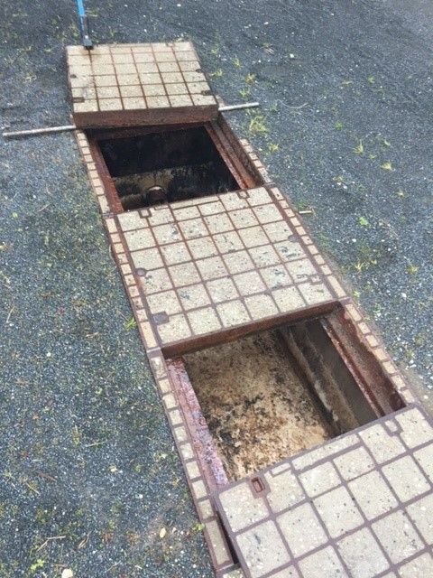A hole in the ground with a brick in it.