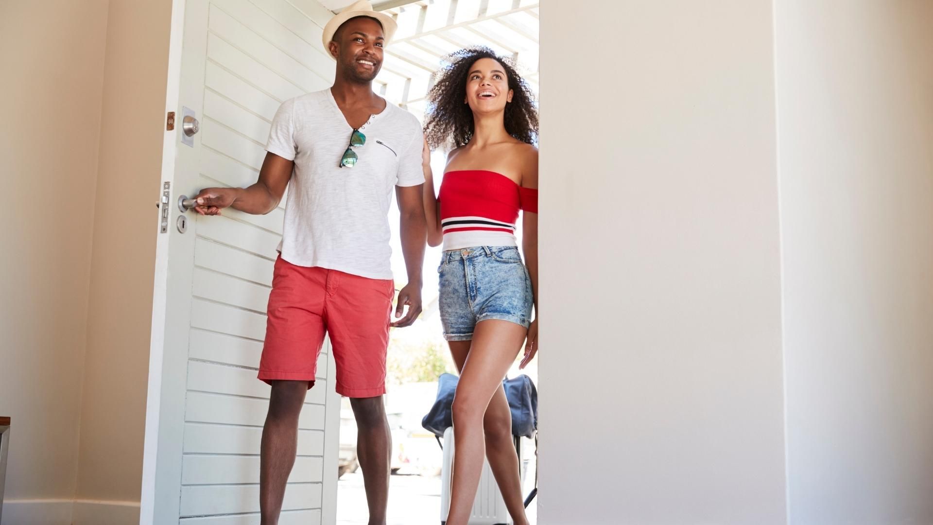 Un homme et une femme se tiennent devant une porte.