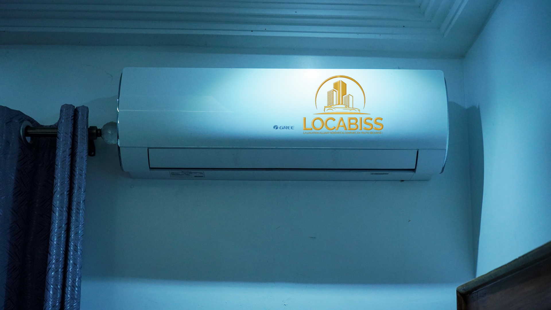 Un climatiseur blanc est accroché au mur d'une pièce.