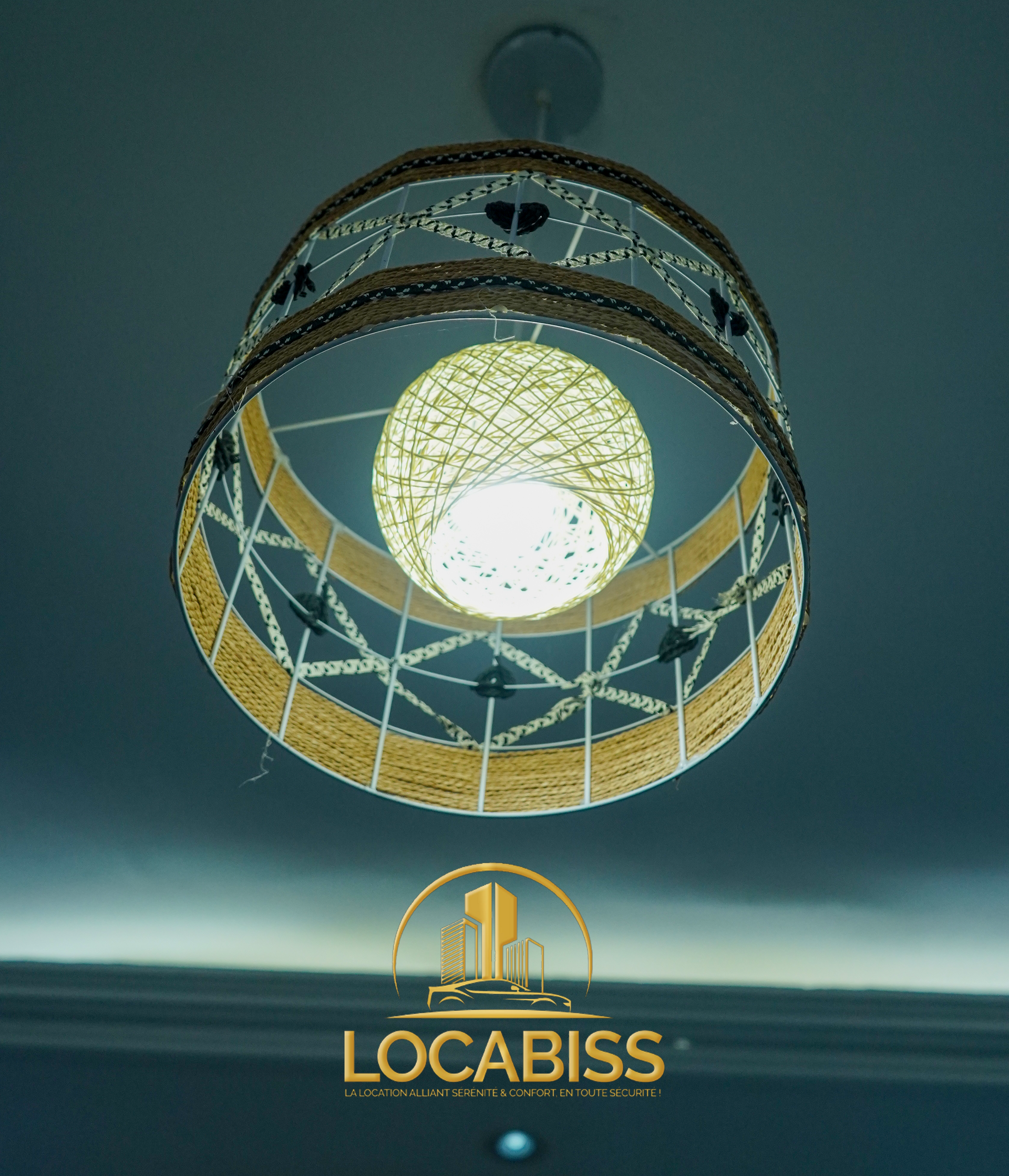 Une lumière suspendue au plafond avec un logo pour locabiss en arrière-plan