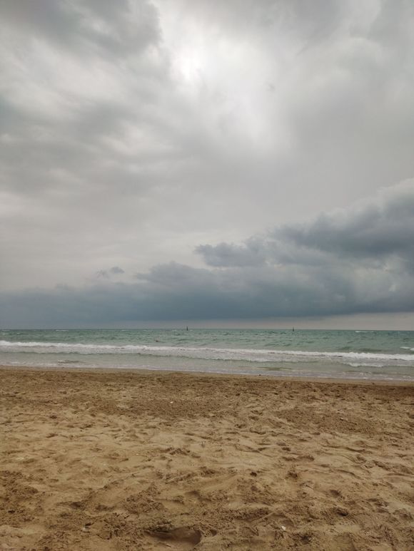 Overcast beach with calm ocean waves and a sandy shore