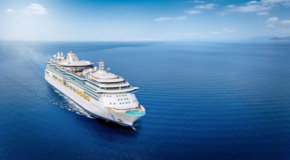 White cruise ship sailing on a calm blue ocean under a clear sky