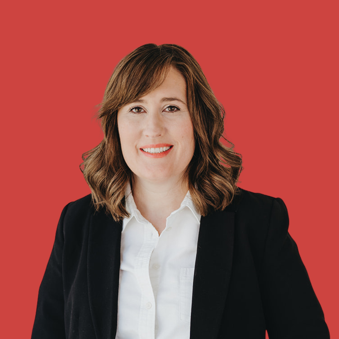 A woman in a black jacket and white shirt is smiling for the camera.